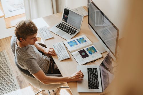 a person sitting at a table using a laptop computer